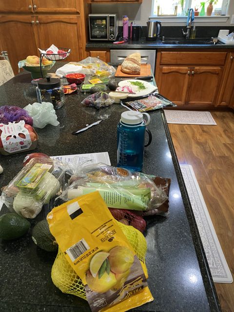 A kitchen counter mid-project, with produce and notes spread out