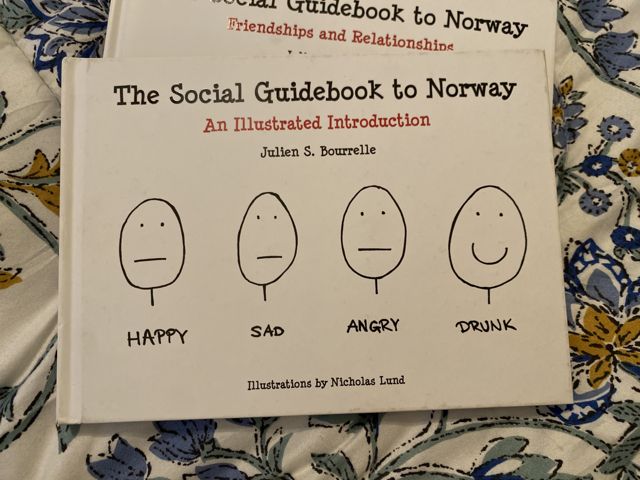 The Social Guidebook to Norway, resting on a floral cloth