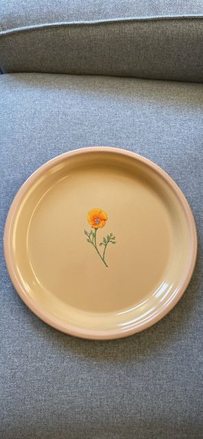 Peach-colored plate with a small painted flower